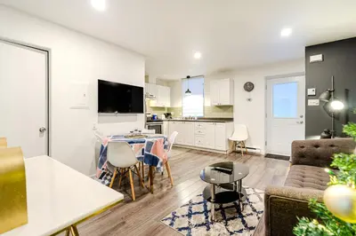 a living room and kitchen with a table and chairs at Cozy 2-Bedroom in Griffintown in Montréal