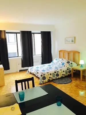 a bedroom with a bed and a table with a table sidx sidx sidx at Stylish Montreal Apartment Comfortable Stay in the Golden Square Mile in Montréal