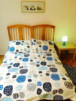 a bed with a blue and white comforter on it at Stylish Montreal Apartment Comfortable Stay in the Golden Square Mile in Montréal