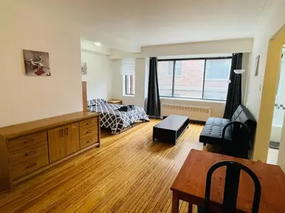 a living room with a bed and a table at Stylish Montreal Apartment Comfortable Stay in the Golden Square Mile in Montréal