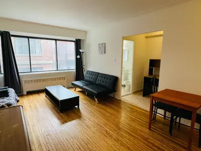 a living room with a couch and a table at Stylish Montreal Apartment Comfortable Stay in the Golden Square Mile in Montréal