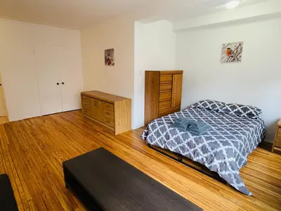 a bedroom with a bed and a wooden floor at Stylish Montreal Apartment Comfortable Stay in the Golden Square Mile in Montréal