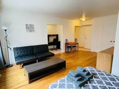 a living room with a black couch and a table at Stylish Montreal Apartment Comfortable Stay in the Golden Square Mile in Montréal