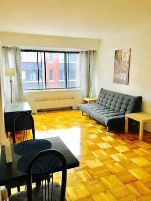 a living room with a couch and a table at Stylish Montreal Apartment Comfortable Stay in the Golden Square Mile in Montréal