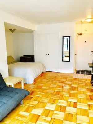 a room with two beds and a wooden floor at Stylish Montreal Apartment Comfortable Stay in the Golden Square Mile in Montréal