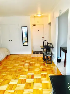 a living room with a wooden floor and a table at Stylish Montreal Apartment Comfortable Stay in the Golden Square Mile in Montréal