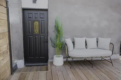 a porch with a couch and a plant in front of a door at Studio #2 - Self Check-In - Plateau - St-Denis in Montréal