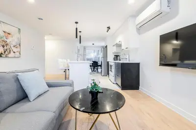 a living room with a couch and a table at T3 10 mins to La Ronde nice , Cozy 3 bedroom longueuil in Longueuil