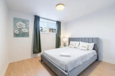 a bedroom with a large bed and a window at T3 10 mins to La Ronde nice , Cozy 3 bedroom longueuil in Longueuil