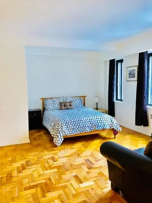 a bedroom with a bed and a wooden floor at Stylish Montreal Apartment Comfortable Stay in the Golden Square Mile in Montréal
