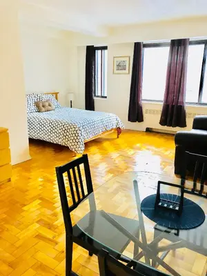 a living room with a bed and a glass table at Stylish Montreal Apartment Comfortable Stay in the Golden Square Mile in Montréal