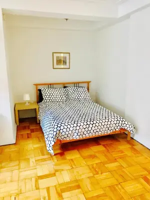 a bedroom with a bed and a wooden floor at Stylish Montreal Apartment Comfortable Stay in the Golden Square Mile in Montréal