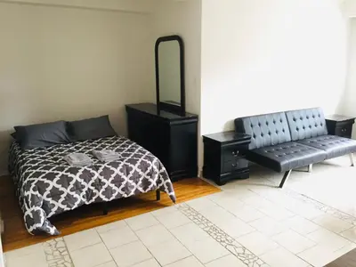 a bedroom with a bed and a mirror and a bench at Stylish Montreal Apartment Comfortable Stay in the Golden Square Mile in Montréal