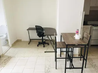 a room with two tables and a chair and a desk at Stylish Montreal Apartment Comfortable Stay in the Golden Square Mile in Montréal