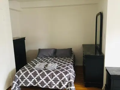 a bedroom with a bed with a black dresser at Stylish Montreal Apartment Comfortable Stay in the Golden Square Mile in Montréal