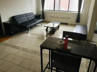 a living room with black furniture and a table at Stylish Montreal Apartment Comfortable Stay in the Golden Square Mile in Montréal