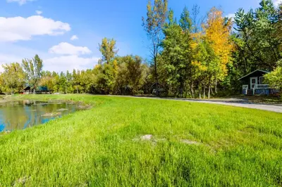 a large grassy field with a house in the background at Chalet 3 - Domaine de l Archipel in Sorel