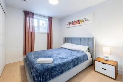 a bedroom with a blue bed and a window at Longueuil New Stylish 3-BDR free parking close to Dix 30&DT in Longueuil