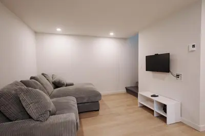 a living room with a couch and a flat screen tv at Chalets OST Shefford FORFAIT GROUPE in Shefford