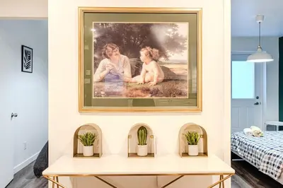 a painting on a wall above a table with potted plants at Bright stay in Griffin Town in Montréal
