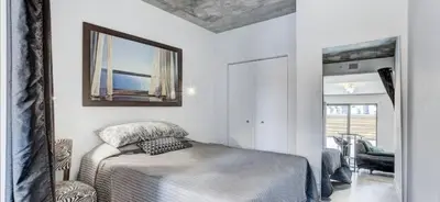 a white bedroom with a bed and a mirror at INCh in Montréal