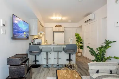 a kitchen with a counter and stools in a room at Stylish 3BR in Griffintown in Montréal