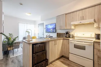 a kitchen with wooden cabinets and a counter top at Stylish 3BR in Griffintown in Montréal