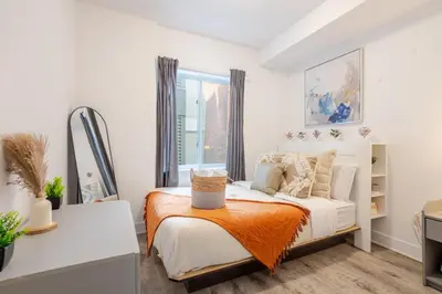 a bedroom with a bed and a window at Stylish 3BR in Griffintown in Montréal