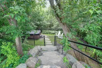 a garden with a fence and a tree at 853 condo in Bromont Vieux Village mountain view in Bromont