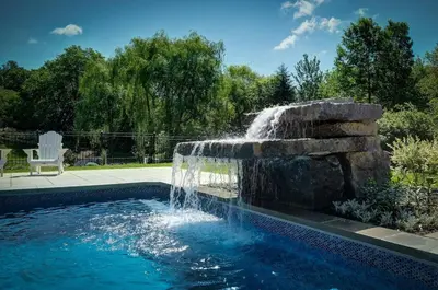 a swimming pool with a fountain in a yard at Loft at 913 Shefford in Bromont