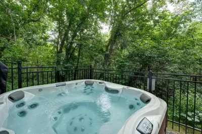 a jacuzzi tub on a balcony with trees at Loft at 913 Shefford in Bromont