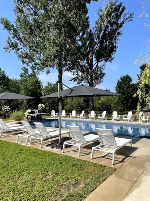 a group of chairs and umbrellas next to a pool at Loft at 913 Shefford in Bromont