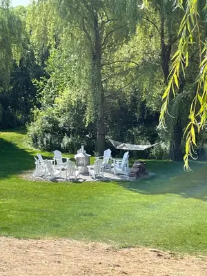 a group of white chairs and a table in the grass at 891 shefford 4-bedroom house in Bromont