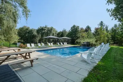 a pool with a bunch of chairs and a table at room with private bathroom 837 shefford suite 105 in Bromont