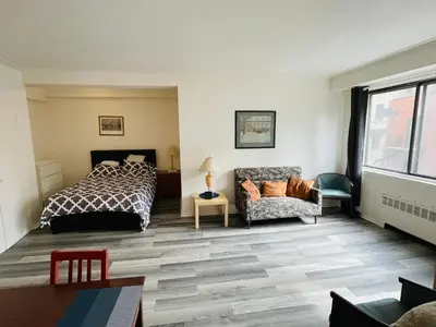 a bedroom with a bed and a couch at Stylish Montreal Apartment Comfortable Stay in the Golden Square Mile in Montréal