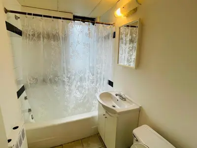 a bathroom with a sink and a shower curtain at Stylish Montreal Apartment Comfortable Stay in the Golden Square Mile in Montréal