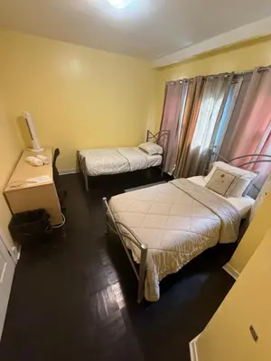 a room with two beds and a table at Montréal Downtown Private Rooms Across Polytechnique in Montréal