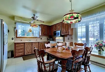 a kitchen with a wooden table and chairs and a chandelier at Private roomC Fee parking 15min downtown in Longueuil