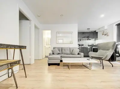 a living room with a couch and two chairs and a table at Superbe 2 chambres à Griffintown in Montréal