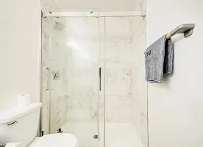 a bathroom with a shower and a toilet at Superbe 2 chambres à Griffintown in Montréal