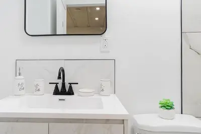 a white bathroom with a sink and a mirror at Room 1 - apartment 2 in a SHARED apartment in Montréal