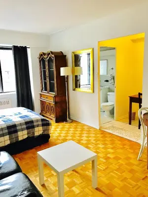 a room with a bed and a table and a mirror at Modern City Living in the Golden Square Mile in Montréal