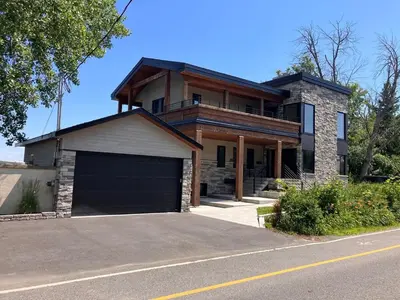 a large house with a garage in front of it at Modern apartment with magnificent views in Vaudreuil-Dorion