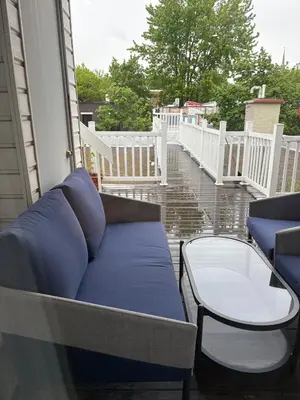 a porch with a blue couch and a table at Shope & Stay Central 7 in Montréal