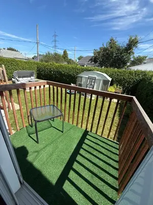 a deck with a bench and a chair on it at Chambre queen near Montreal in Sainte-Catherine