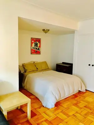 a bedroom with a white bed and a wooden floor at Modern Apartment City Living in the Golden Square Mile in Montréal