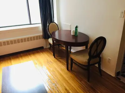 a table and chairs in a room with a window at Modern City Studio Living in the Golden Square Mile in Montréal