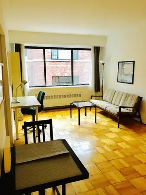 a living room with a couch and a table at Modern City Studio Living in the Golden Square Mile in Montréal