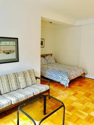 a living room with a couch and a bed at Modern City Studio Living in the Golden Square Mile in Montréal