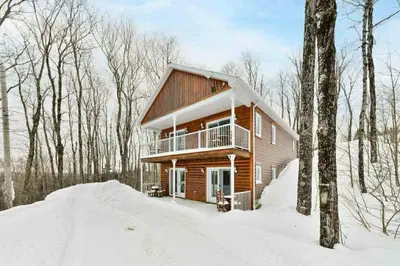 a log cabin in the woods in the snow at Suite 3 - Val-Racine in Notre-Dame-Des-Bois